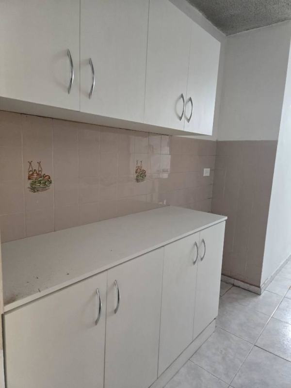 Kitchen with white cabinets and decorative tile backsplash at PH La Alameda Panama City