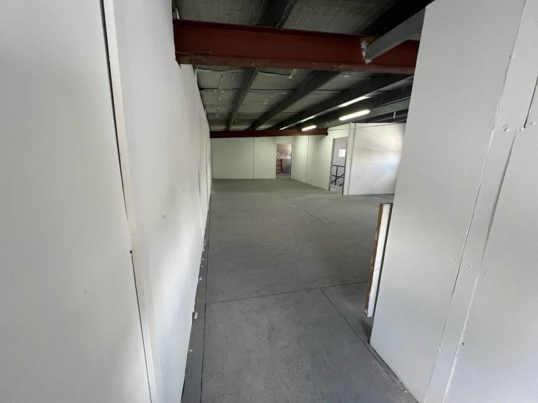 Warehouse mezzanine with white walls concrete floor exposed beams in commercial building El Ingenio Panama
