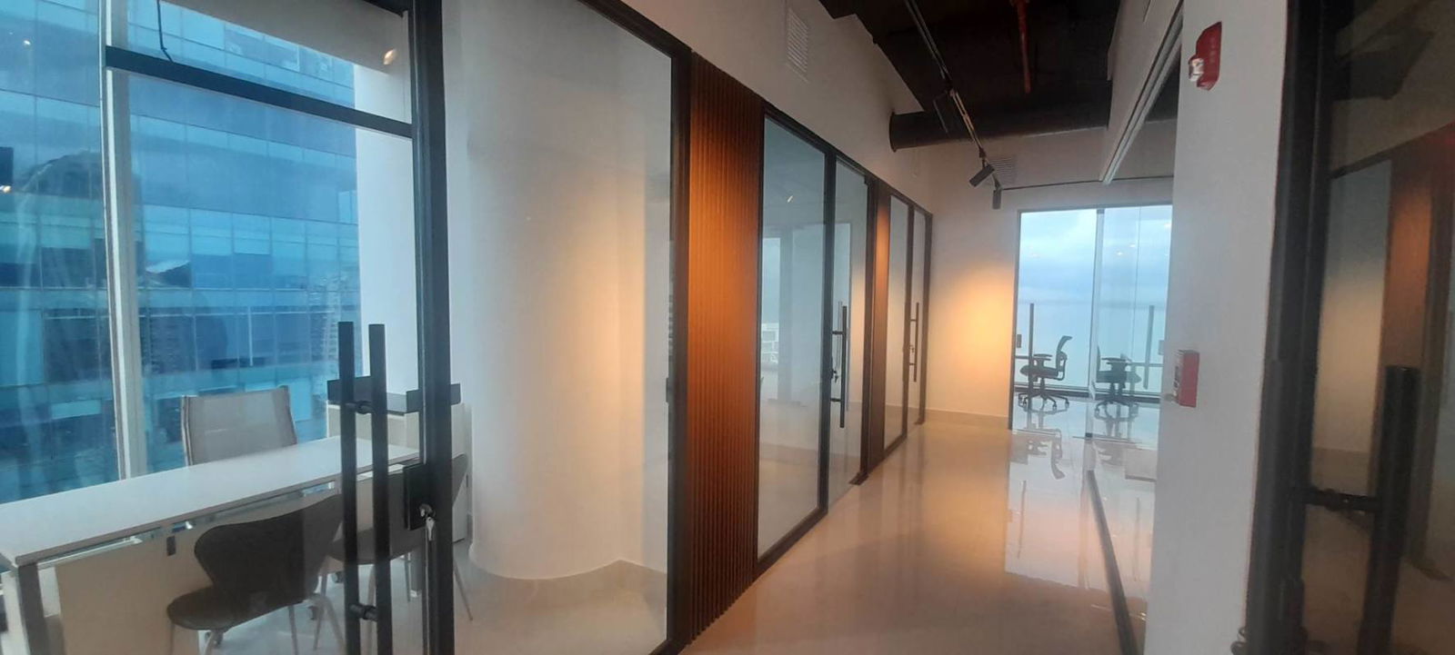 Modern corporate meeting room with glass partitions overlooking ocean in PH Oceania Panama