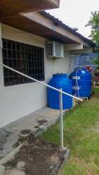 Side of house with water reserve tanks and garden fenced yard Chiriqui Panama