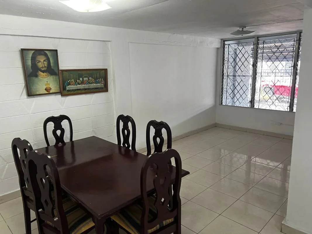 Minimalist bedroom with metal frame bed, vintage chairs, tiled floor La Loceria Panama