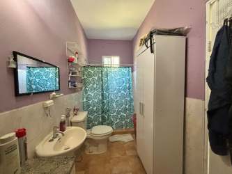 Spacious covered terrace overlooking large yard with mature trees at Gorgona beach house for sale