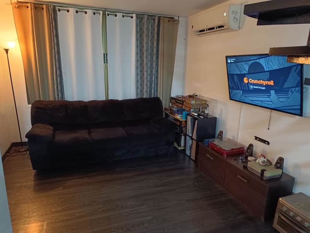 Cozy living room with black sofa, wall mounted TV and curtains in PH Hato Pintado Tower Panama City
