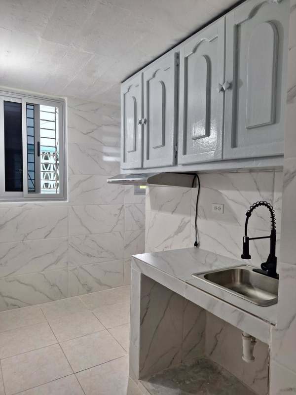 Minimalist kitchen with marble-style tiles white upper cabinets PH Santa María Panama