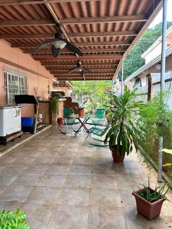 Covered patio area with tiled flooring, grill station, ceiling fans, and outdoor seating Condado del Rey Panama