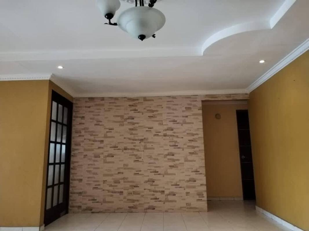 Living room interior with accent stone wall, decorative chandelier Villas de Don Bosco Panama