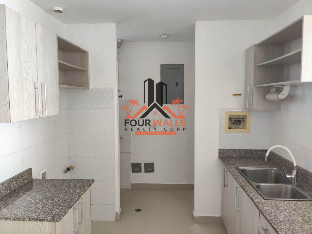Compact modern kitchen with granite countertop, cabinets, adjacent laundry at PH Alta Terra Panama