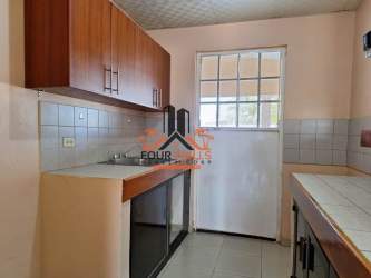 Kitchen with wood cabinets, tiled countertop window Urbanización El Mirador Antón Panama