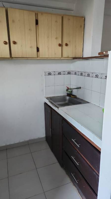 Small kitchen with wooden cabinets, tiled counters, ceramic floor Los Libertadores Panama City