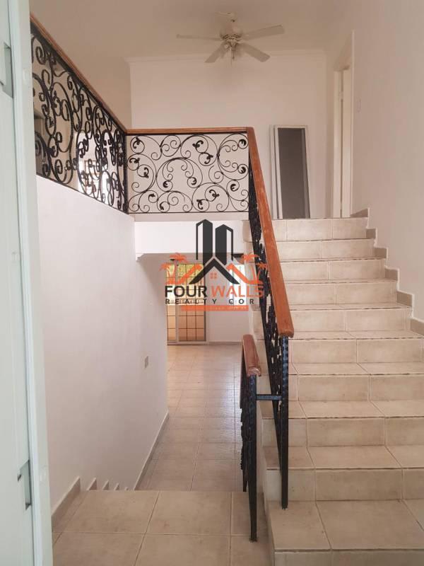 Bright staircase hallway with wrought iron railings and tile flooring in Panama house