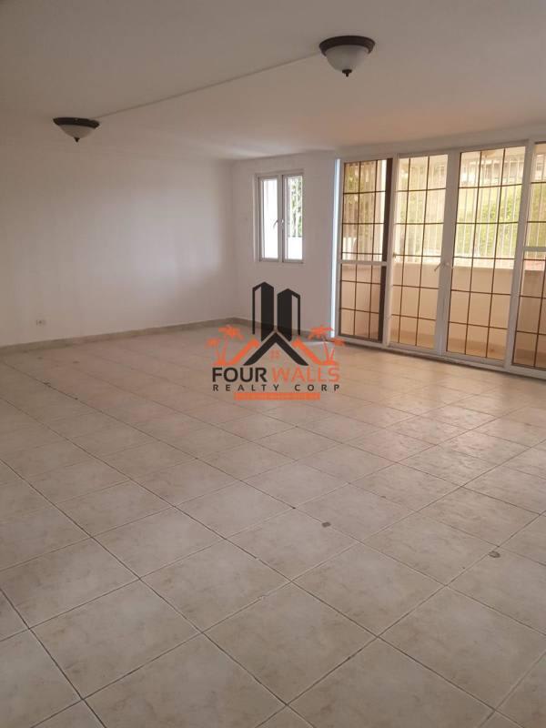 Open plan living dining area with glass doors and tile floors in Villas de Las Fuentes Panama