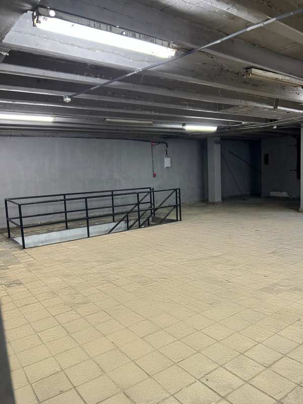 Empty industrial basement space concrete ceiling tiled floors metal railing Calidonia Panama