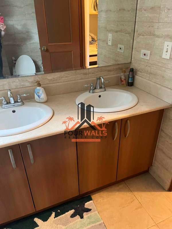 Living room with gray sectional sofa, split AC, TV, large windows in PH Amador Hill Amador Causeway Panama