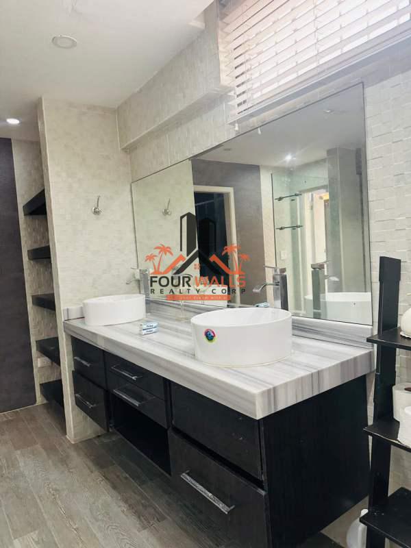 Contemporary bathroom with double sinks, granite counters, mirror in Villa de las Fuentes Panama