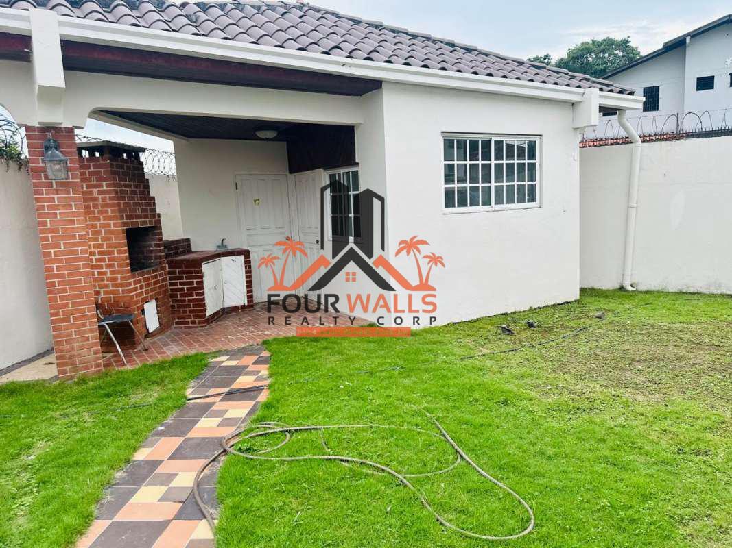 Outdoor patio with barbecue, covered area, lawn and garden at Villa de las Fuentes Panama City