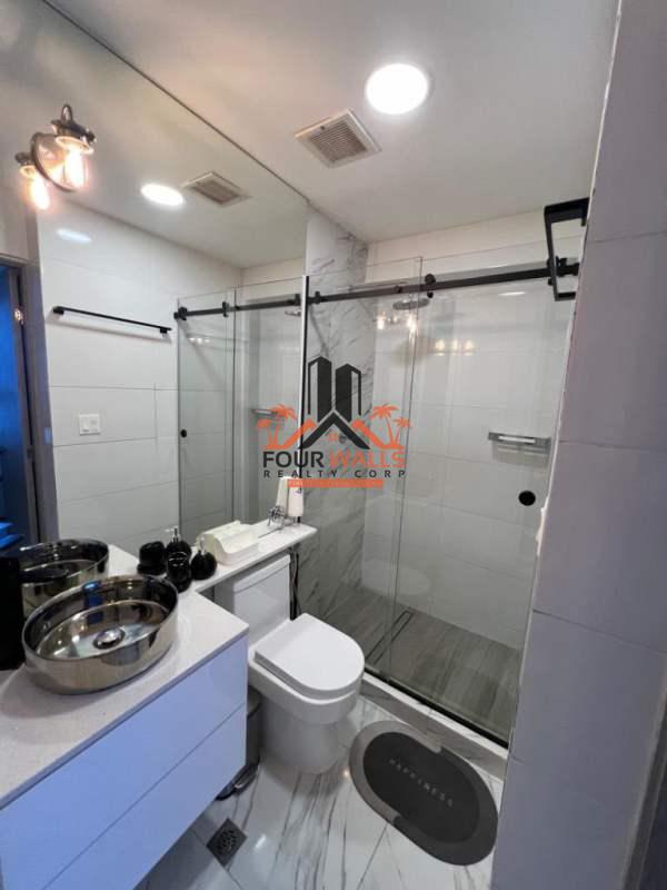 Modern bathroom with dual vessel sinks, glass shower, marble tile at PH The Sands Panama