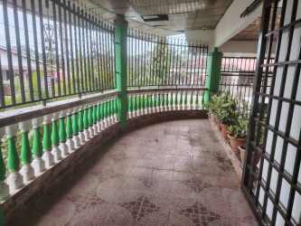 Bathroom featuring black toilet, checkered wall tiles and shower curtain in La Chorrera