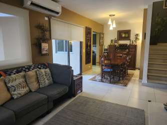 Covered terrace overlooking lush backyard in Panama Pacifico Woodlands townhome