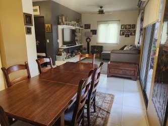 Open plan living and dining room with large windows overlooking garden in Woodlands Panama Pacifico