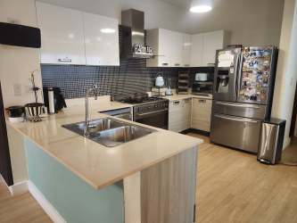 Modern kitchen with island stainless steel appliances in River Valley Panama Pacifico home