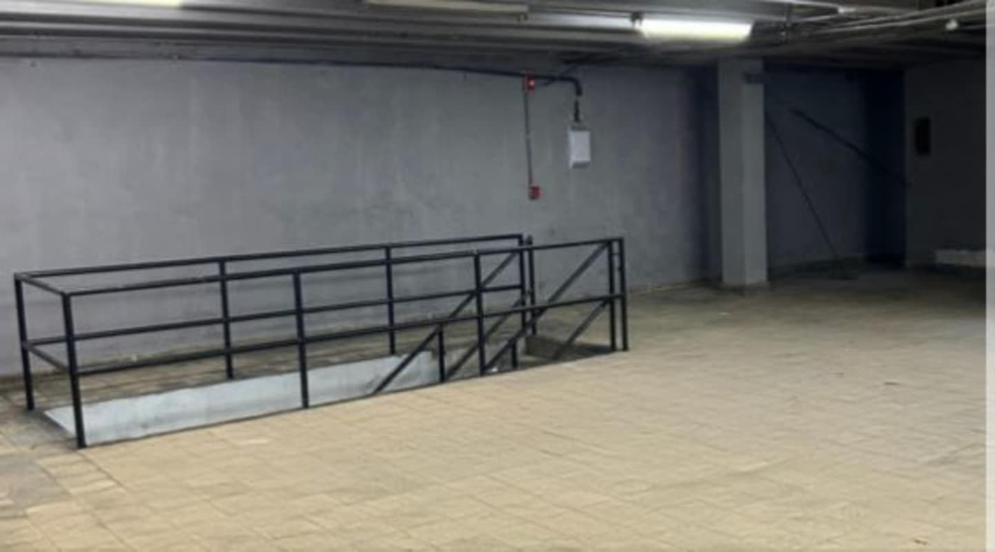 Underground parking or storage with metal railings and concrete walls in Calidonia commercial district