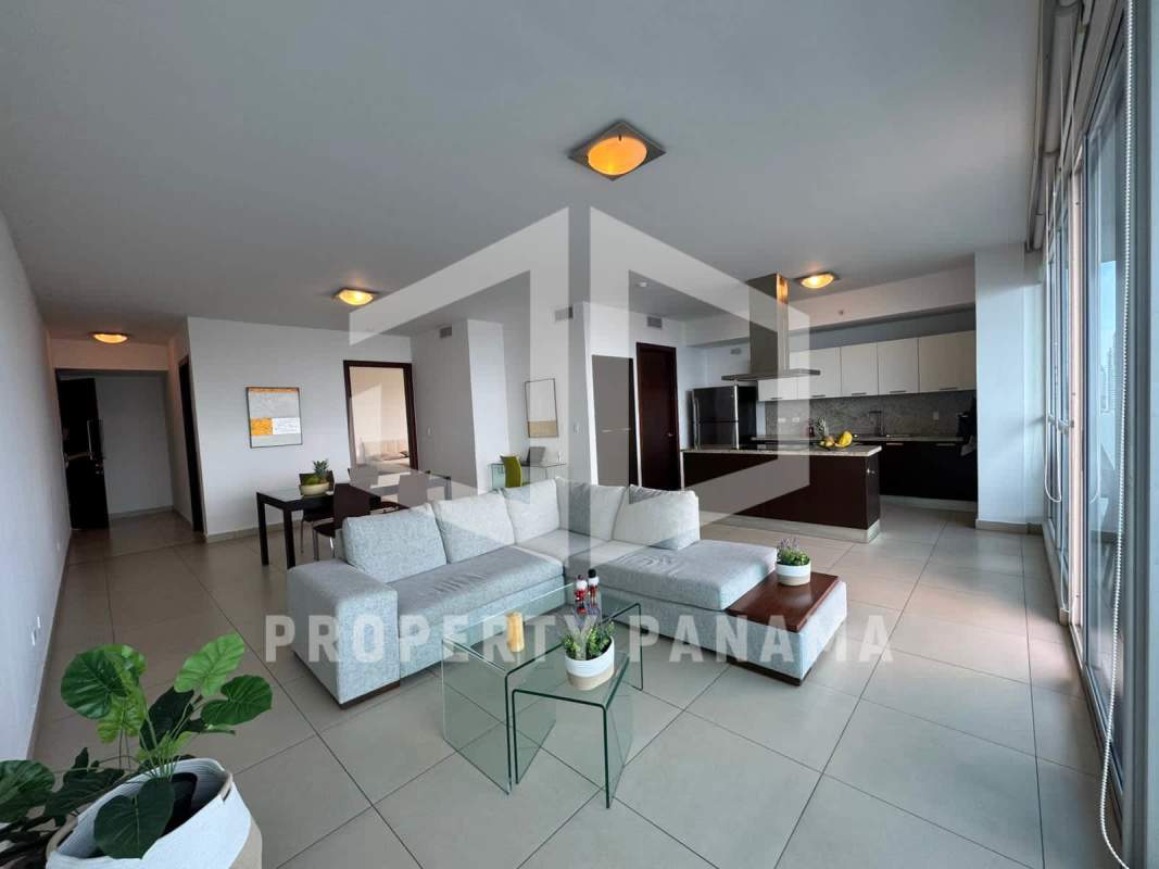 Modern open-concept apartment with kitchen, dining and living area facing skyline and ocean at PH Oceanaire