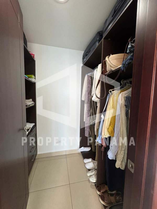 Bright open-plan living and dining area with floor-to-ceiling windows and balcony access overlooking Pacific Ocean