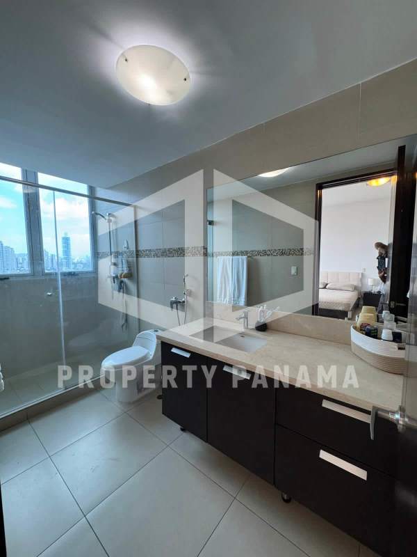 Contemporary master bathroom with large window, glass shower enclosure and city skyline views in PH Oceanaire