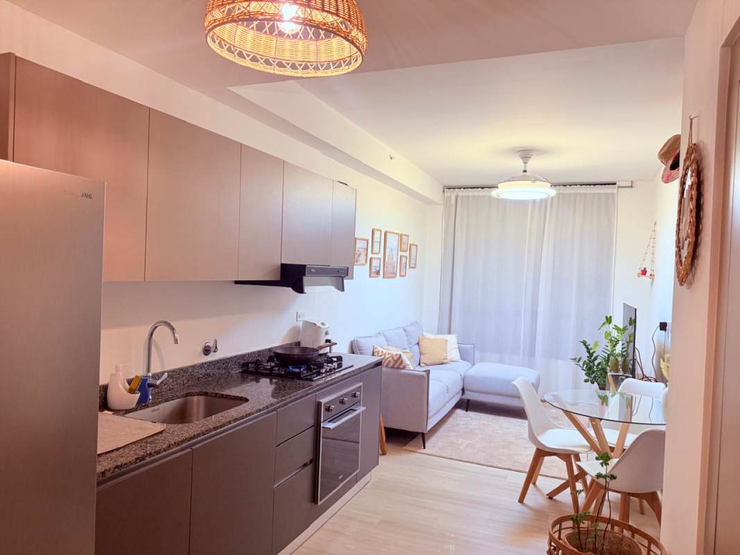 Open space living and dining area with kitchen in PH Quatrium apartment Panama City