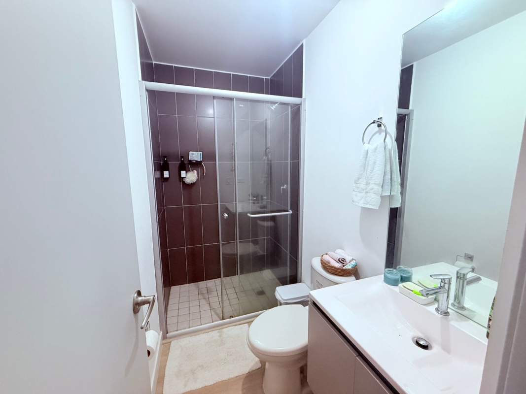 Bathroom with glass-enclosed shower, tiled walls and vanity in PH Quatrium Panama