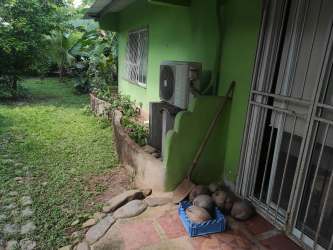Indoor rustic dining space with large wooden table, tiled floor, and hammocks in tropical coastal house Nombre de Dios Panama