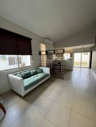 Bright open-plan living dining room with porcelain floors and large window in PH Senderos Costa Verde