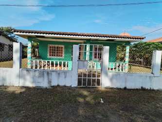 Blue single-story house with covered porch driveway landscaped yard rental Las Tablas Panama