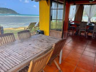 Eclectic dining area with windows opening to Caribbean Sea at Panama beachfront home La Guaira