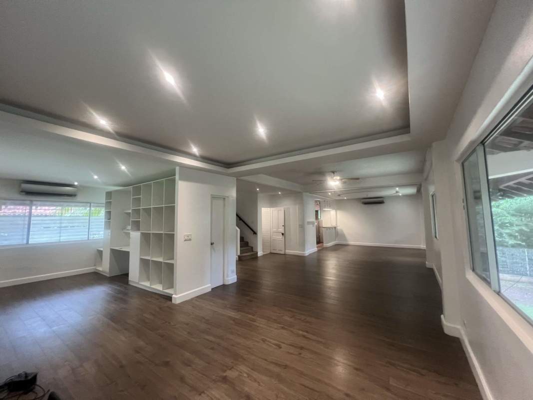 Open concept living space with wood floors, recessed lighting, dark stair railing in Clayton Panama home