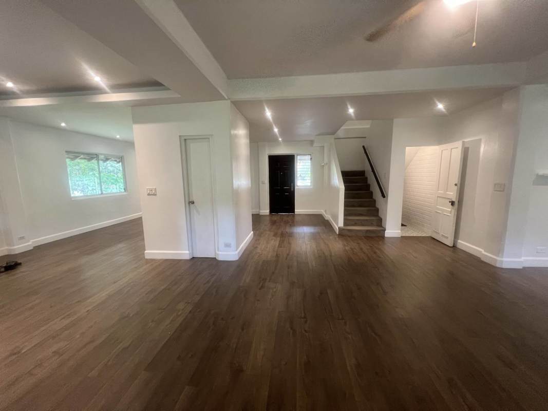Spacious entry and living room with wood flooring and tray ceiling in Clayton family residence