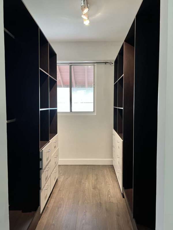 Bedroom with wood floors, large window, white walls and AC unit in Clayton house