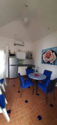 Open kitchen with dining table, blue decor, fridge at Costa Grande Beach property Nueva Gorgona Panama