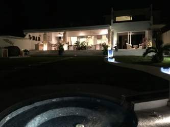 Illuminated patio with jacuzzi night-time modern luxury beachfront villa Costa Esmeralda Panama