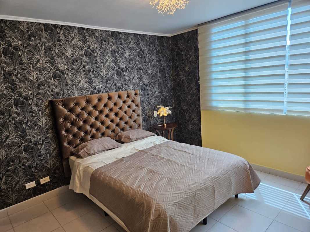 Modern bedroom with tufted bedhead, accent wall, blinds in PH Miro El Cangrejo Panama