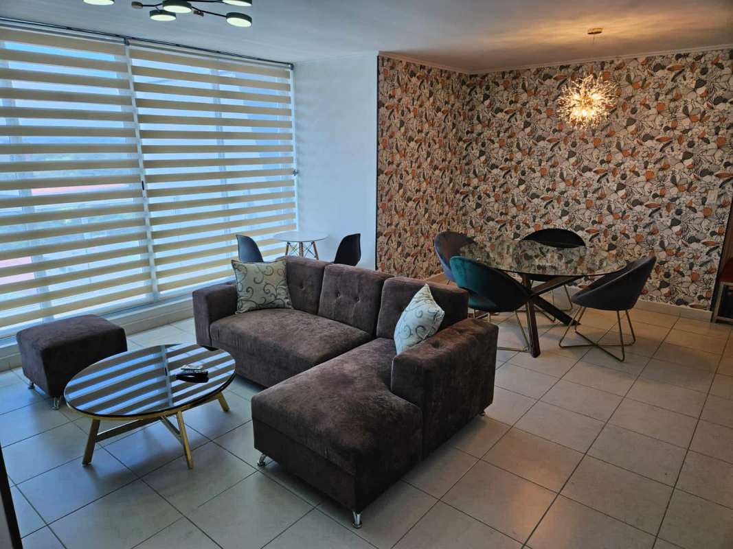 Open living dining area with large windows and sectional sofa in PH Miro El Cangrejo Panama City