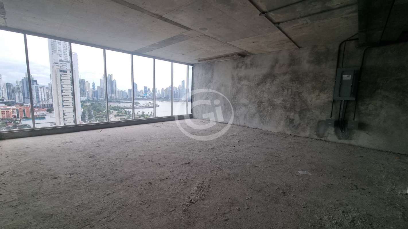 Grey shell office space with large floor-to-ceiling windows overlooking Panama City's skyline and bay