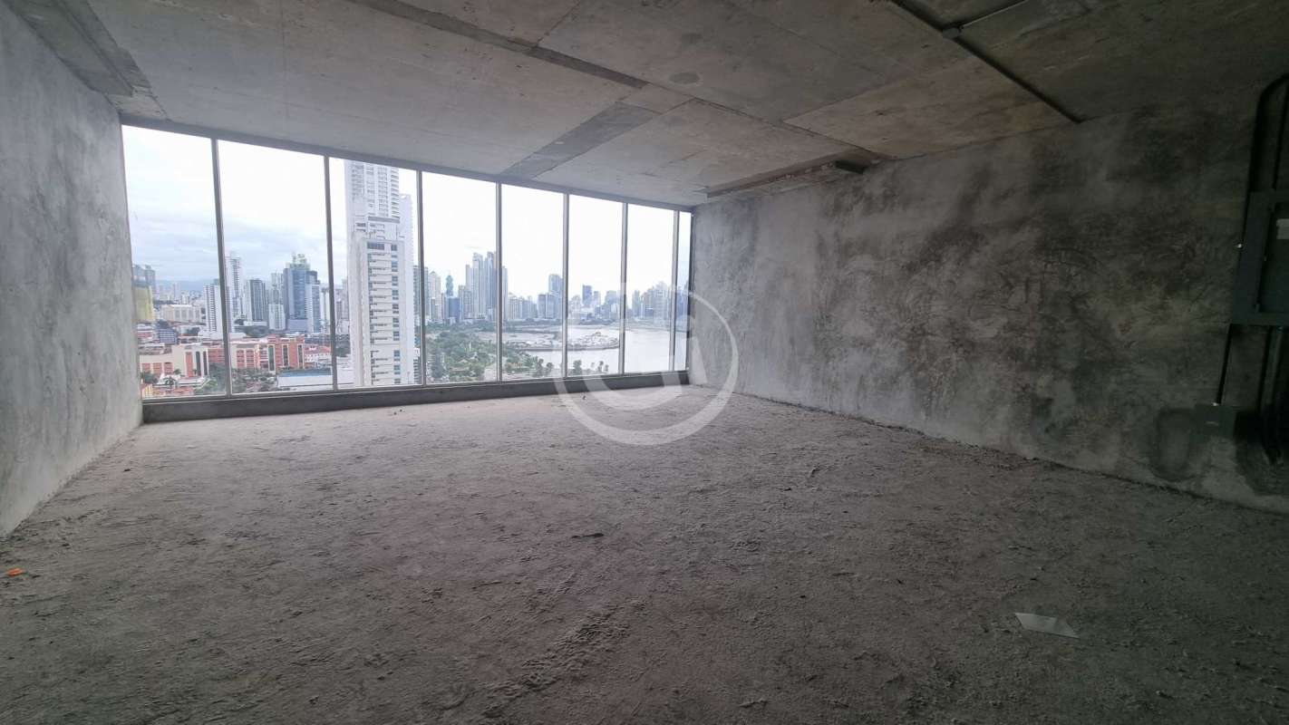 Raw office space with concrete floor, exposed ceiling, large windows with city skyline view in PH BOC Panama