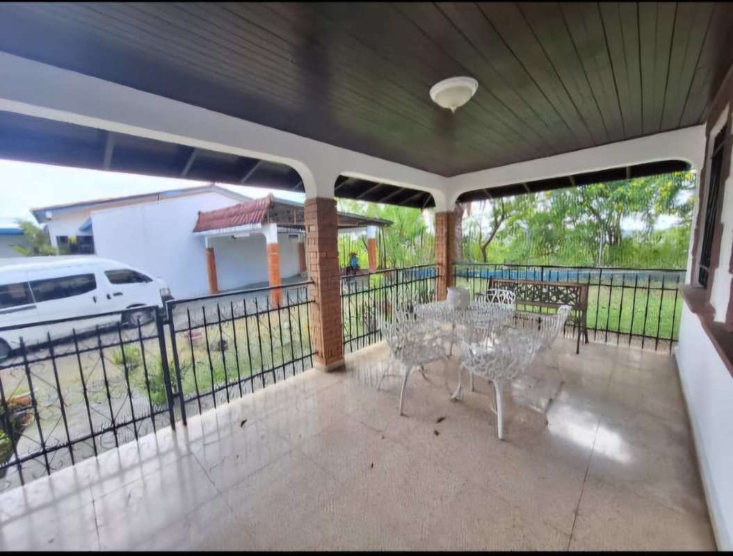 Private backyard with covered terrace, metal railings, outdoor dining and garden in El Dorado Panama