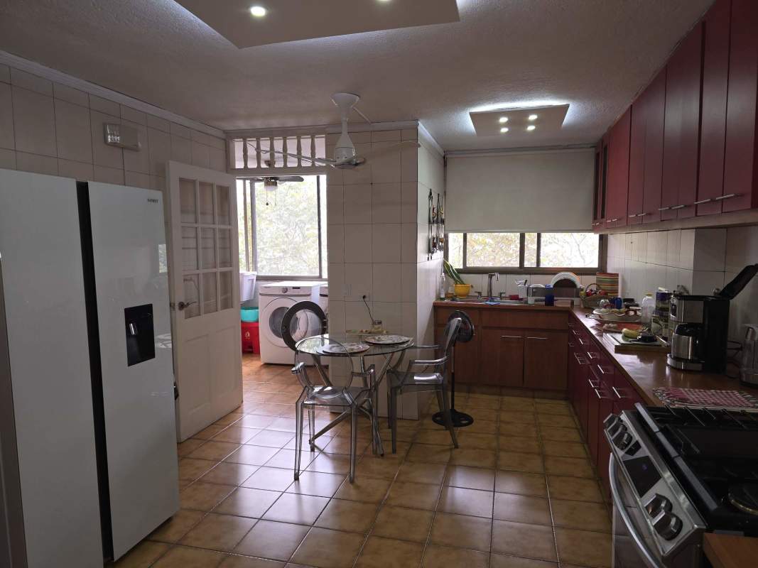 Kitchen with brown tiles, red cabinetry, glass dining table, attached laundry area PH Vista Hermosa Via Argentina