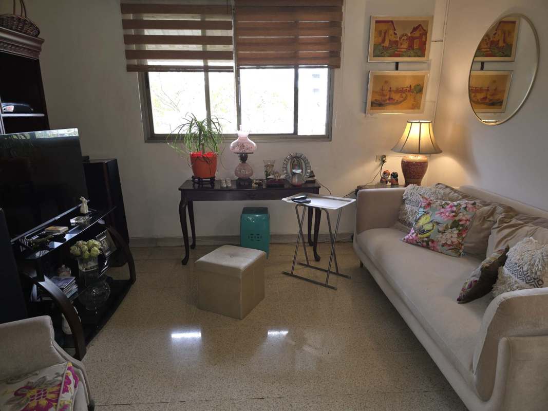 Living room with beige sofa, colorful pillows, decor, large window PH Vista Hermosa Via Argentina Panama