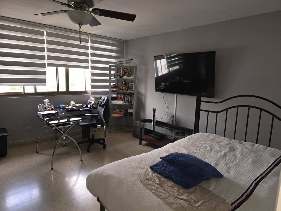 Bedroom with large windows, striped blinds, study desk, TV, and ceiling fan in PH Vista Hermosa Via Argentina Panama