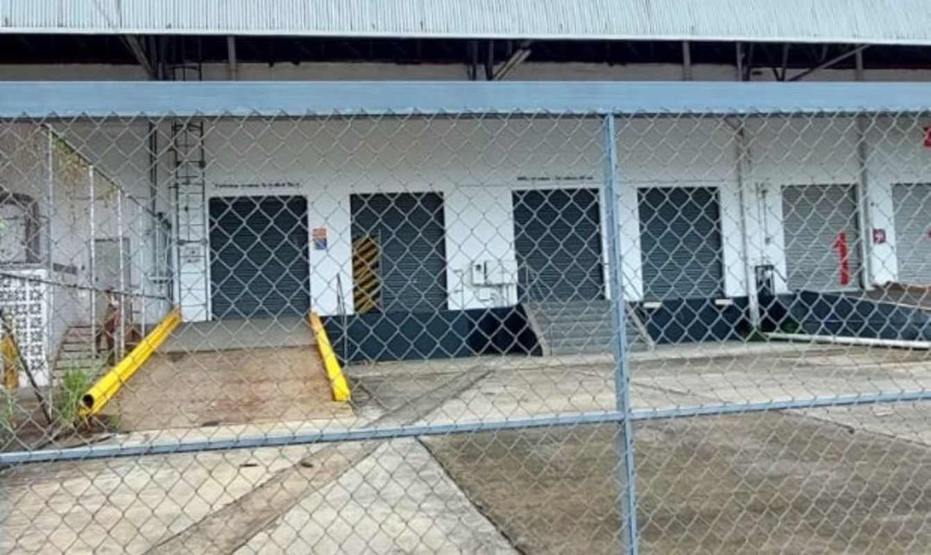 Exterior facade of warehouse with ramp loading docks, security fence, and roll-up doors in Centro Logístico Milla 8 Panama City