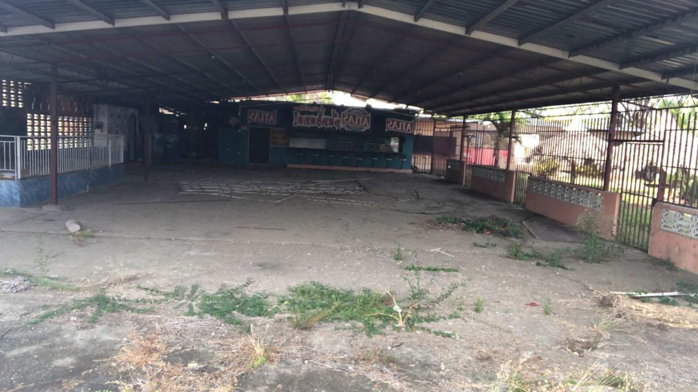 Open outdoor commercial space with fencing and covered patio near Chepo Panama along Pan-American Highway for sale