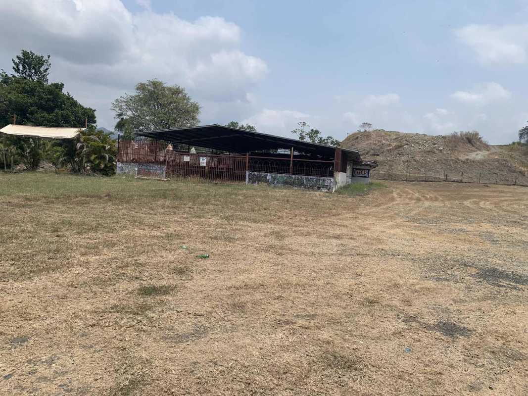 Flat commercial land with rustic covered shed and wire fencing near Chepo Panama along highway ideal for investment
